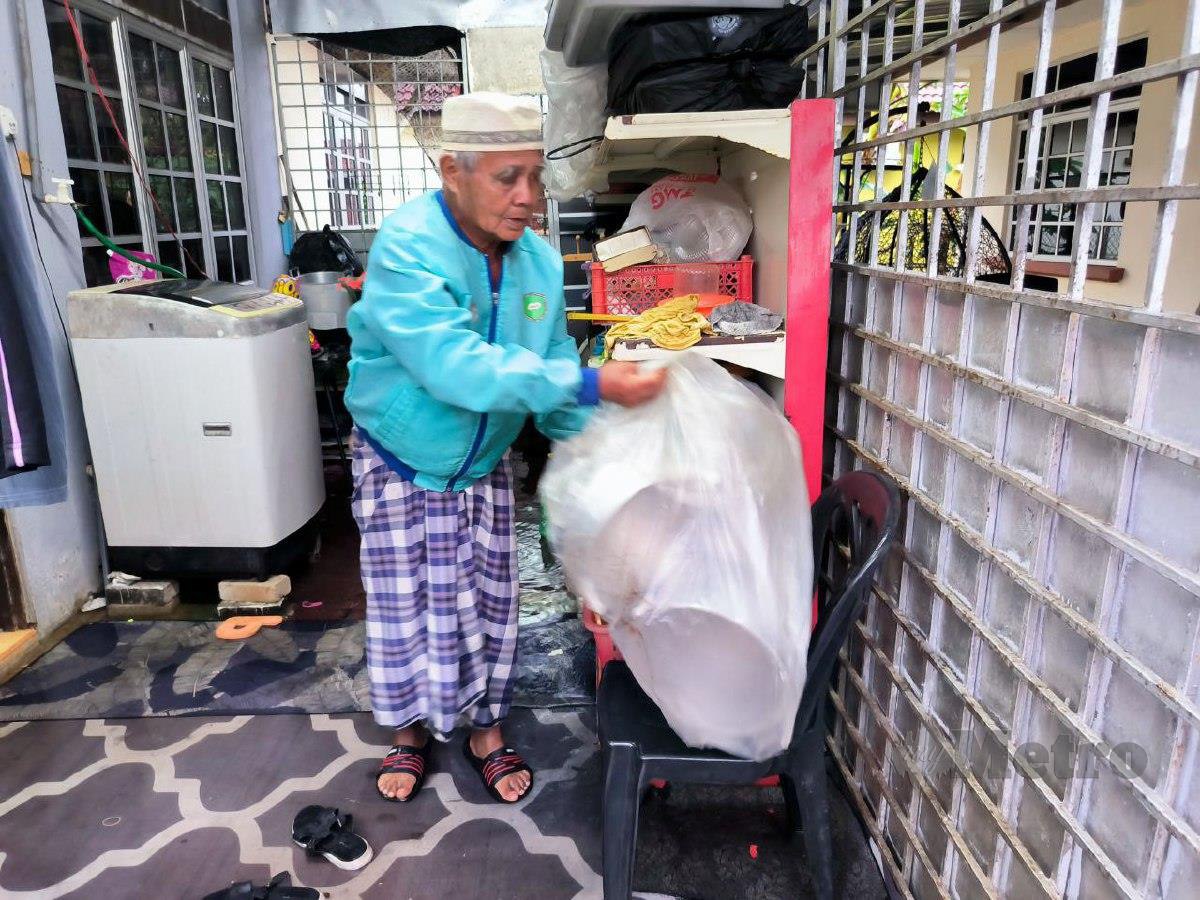 MUSTAFA memindah barangan ke tempat lebih selamat di rumahnya di Taman Desa Tanjung Damai, Gong Badak, Kuala Terengganu. FOTO Malik Muhamad