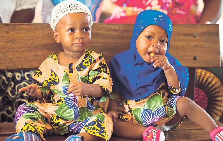 PASANGAN kembar tidak seiras, Kehinda dan Taiwo Akinbola ketika menunggu giliran untuk mendapat suntikan imunisasi di sebuah klinik di Igro Ora. FOTO Agensi