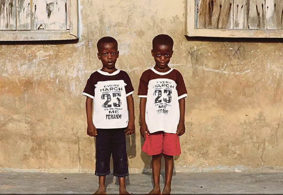 KEMBAR seiras, Taiwo Ahmed dan Kehinde Ahmed berdiri di hadapan rumah mereka. FOTO Agensi