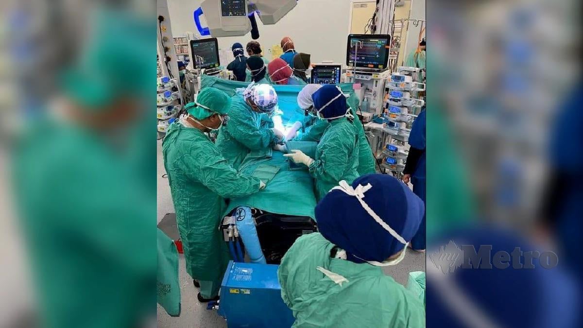 Pakar bedah sedang melakukan pembedahan memisahkan kembar Siam pramatang di HTA semalam. Foto Ihsan KKM