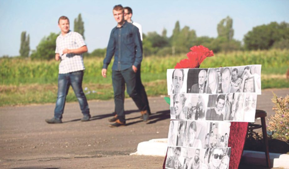 TUGU sementara dengan gambar sebahagian penumpang pesawat MH17 didirikan penduduk Kampung Petropavlivka sempena ulang tahun kedua tragedi itu.