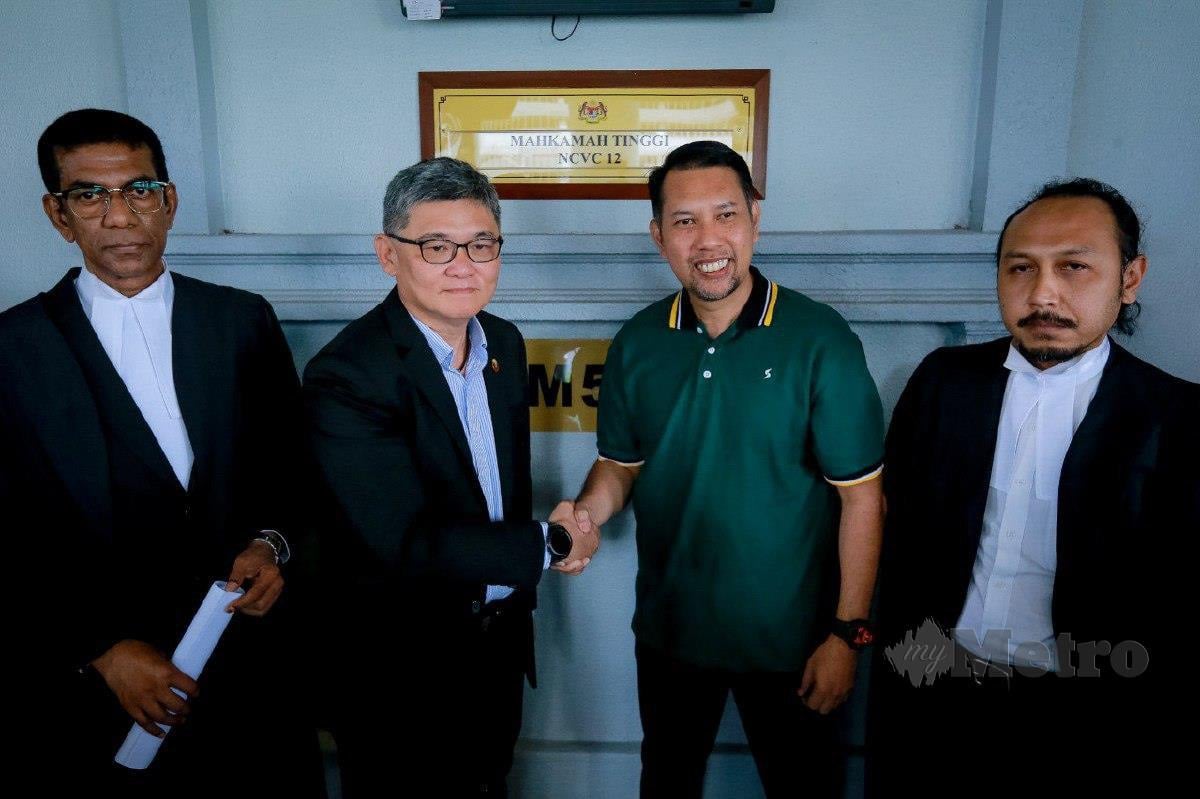 ROSLIN (dua kanan) bersalaman bersama Kenny (dua kiri) selepas kes saman fitnah terhadap Roslin diselesaikan secara baik di Kompleks Mahkamah Kuala Lumpur. FOTO ASYRAF HAMZAH