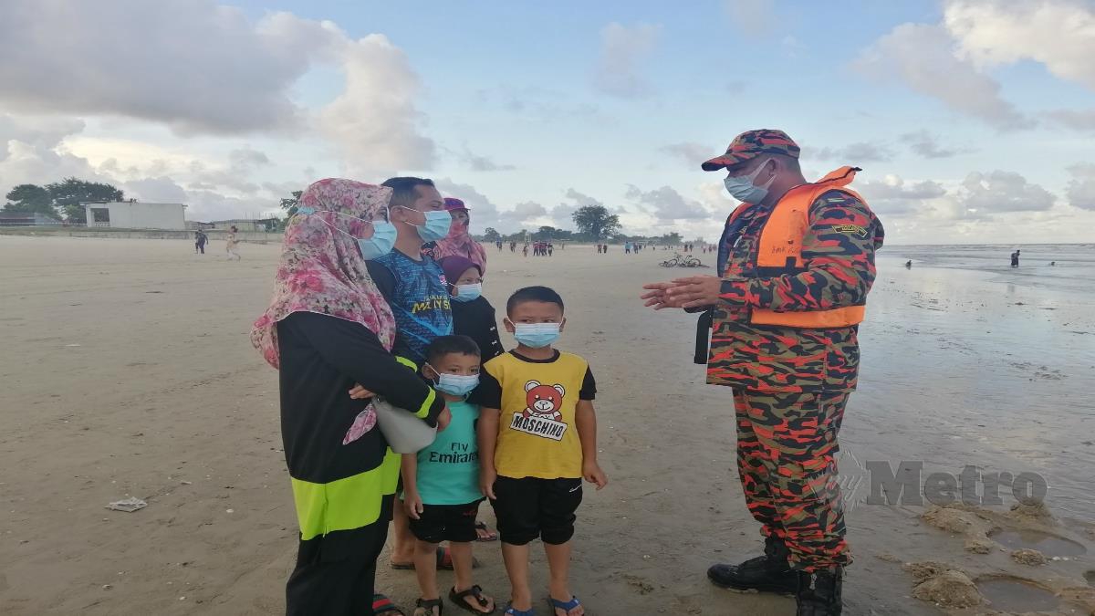 PEGAWAI Operasi Balai Bomba dan Penyelamat (BBP) Kuala Terengganu , Pegawai Bomba Kanan 11 Wan Mohd Azamani Wan Hamzah menasihatkan pengunjung di kawasan Pantai Pandak, Chendering. FOTO ZATUL IFFAH ZOLKIPLY