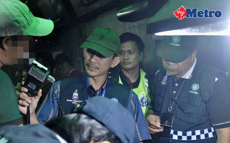 KAKITANGAN JHEAINS memeriksa salah seorang pengunjung dipremis pusat hiburan di Jalan Bundusan, Penampang.