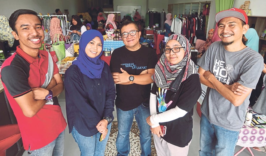 FAIZAL (kanan) dan rakan sukarekawan Kengkawan Project ketika menjayakan pasar amal di Liylin Studio Bandar Kinrara.