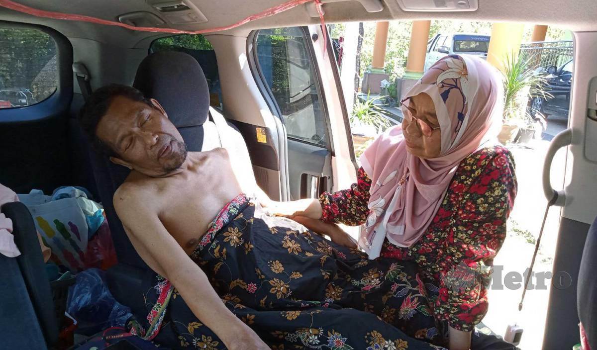 WAN Zaidah (kiri) ketika melayani Azhar yang terpaksa tidur di atas kereta selepas mengalami penyakit misteri hampir setahun lalu. FOTO Baharom Bakar