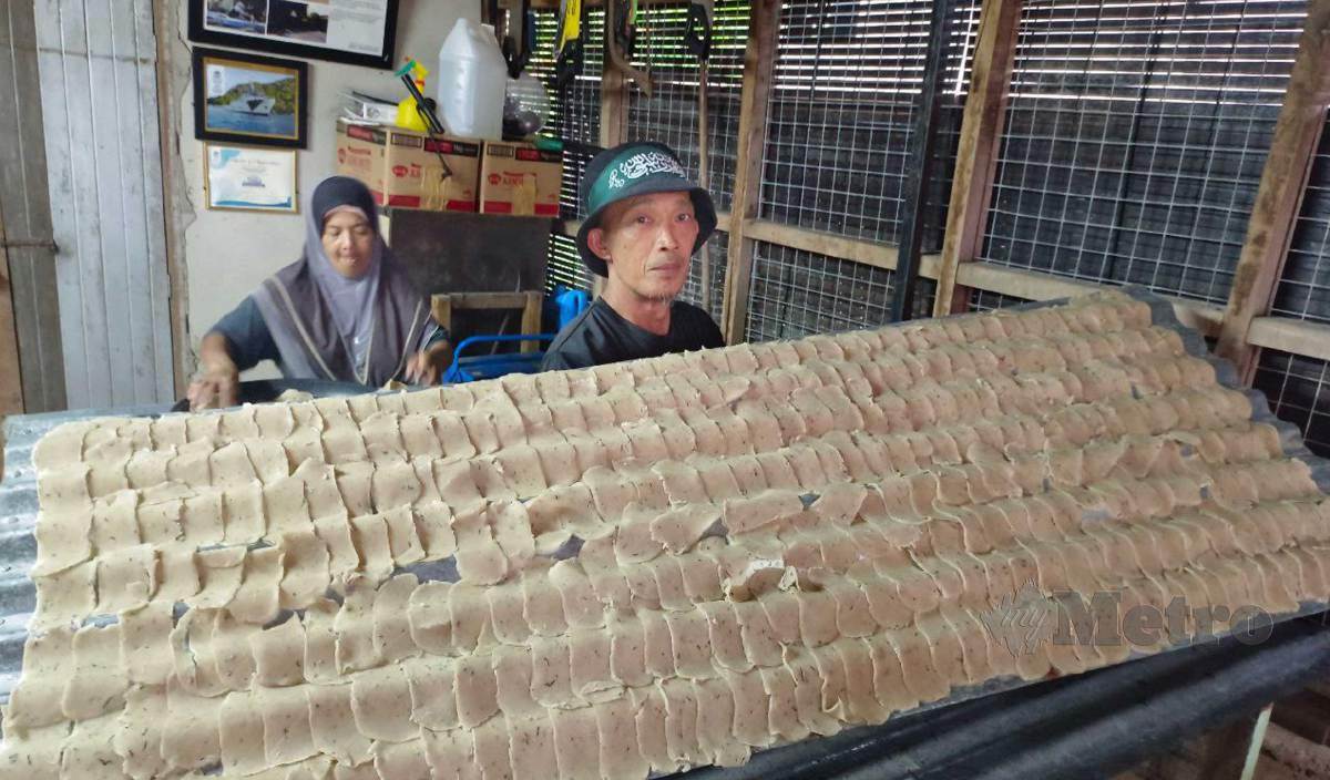 SALIM menunjukkan keropok keping yang siap disusun untuk dimasukkan dalam bilik pengering untuk proses pengeringan di Kampung Mengabang Telung, Batu Rakit. FOTO Faizul Azlan Razak