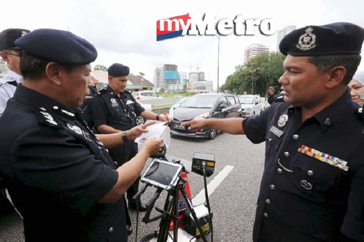Sulaiman ( kiri ) mendengar penerangan daripada DSP Bakri Zainal Abidin (kanan) mengenai Alat ANPR yang digunakan ketika menjalankan Ops Saman Tertunggak di Johor Bahru.  FOTO Zain Ahmed 