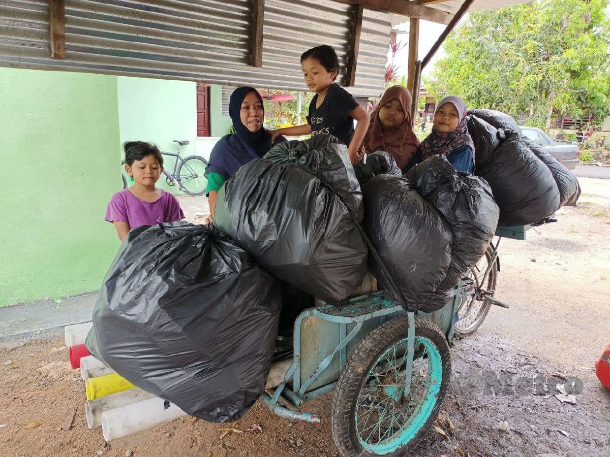 Umi Nur Faizah bersama anak-anaknya dengan barangan lusuh yang dikumpulkan. FOTO NAZRI ABU BAKAR