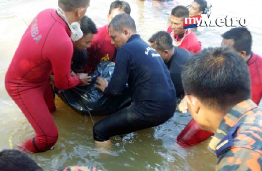 Anggota bomba mengangkat mayat Lizawati Abdullah, 37, dalam tali air. - Foto ZULIATY ZULKIFLI