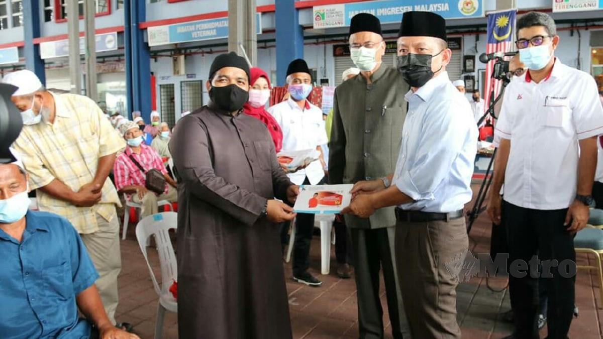 RAZALI (dua kanan) menyampaikan sumbangan kepada imam sambil disaksikan Tengku Ahmad Nadzri (kanan). FOTO BAHAROM BAKAR.