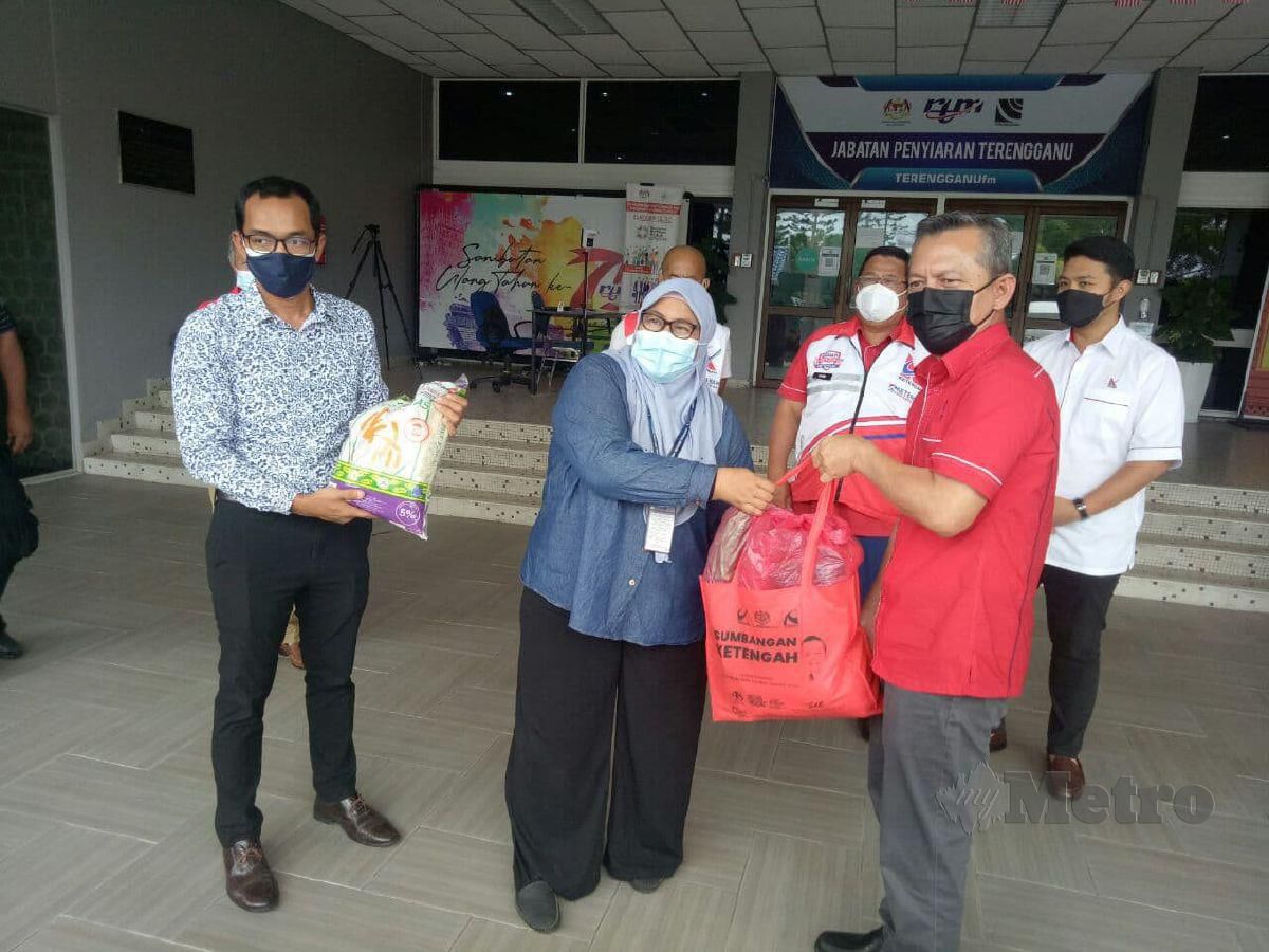 RAZALI (kanan) menyerahkan bantuan bakul makanan di pekarangan Jabatan Penyiaran negeri di Bukit Pak Apil, Kuala Terengganu. FOTO BAHAROM BAKAR.