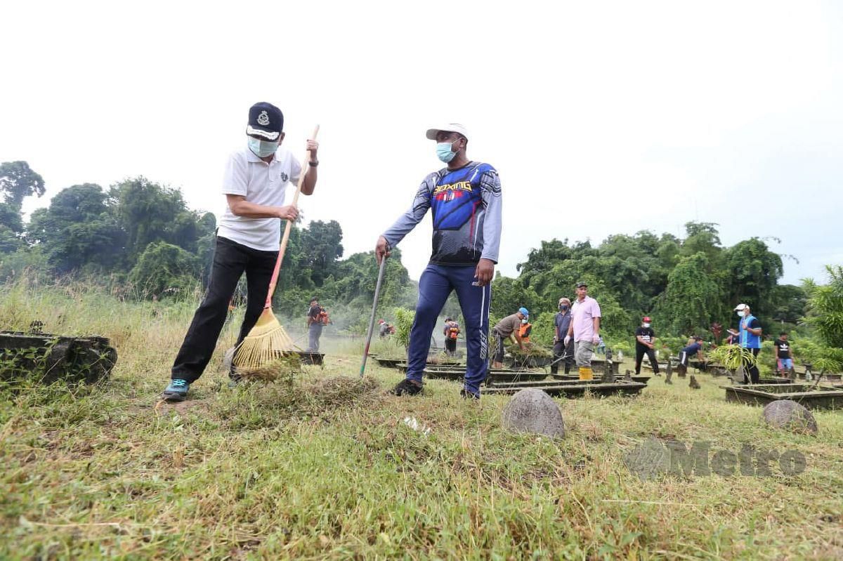 Abdul Rahim (kiri) bersama penduduk kampung bergotong royong membersihkan Tanah Perkuburan Islam Chicha dan Tanjong. FOTO NIK ABDULLAH NIK OMAR