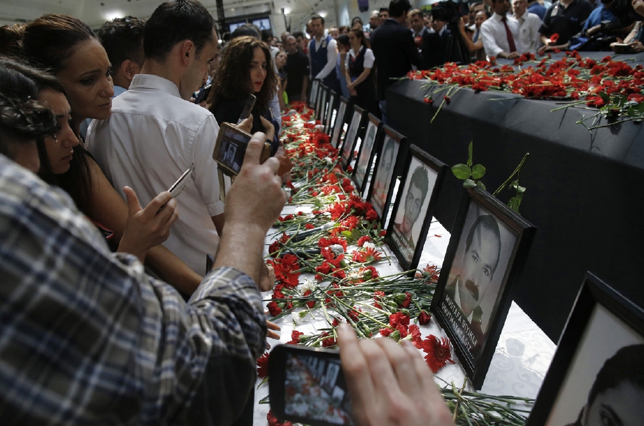 Gambar mangsa serangan bom dipamerkan di Lapangan Terbang Ataturk, Istanbul, semalam.  - Foto AP