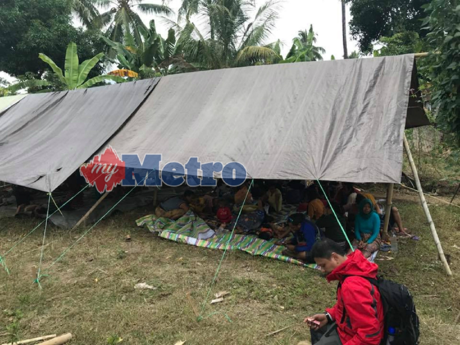 PENDUDUK bergotong-royong membina khemah bagi menempatkan mangsa gempa. FOTO Facebook Ayu Hasman 