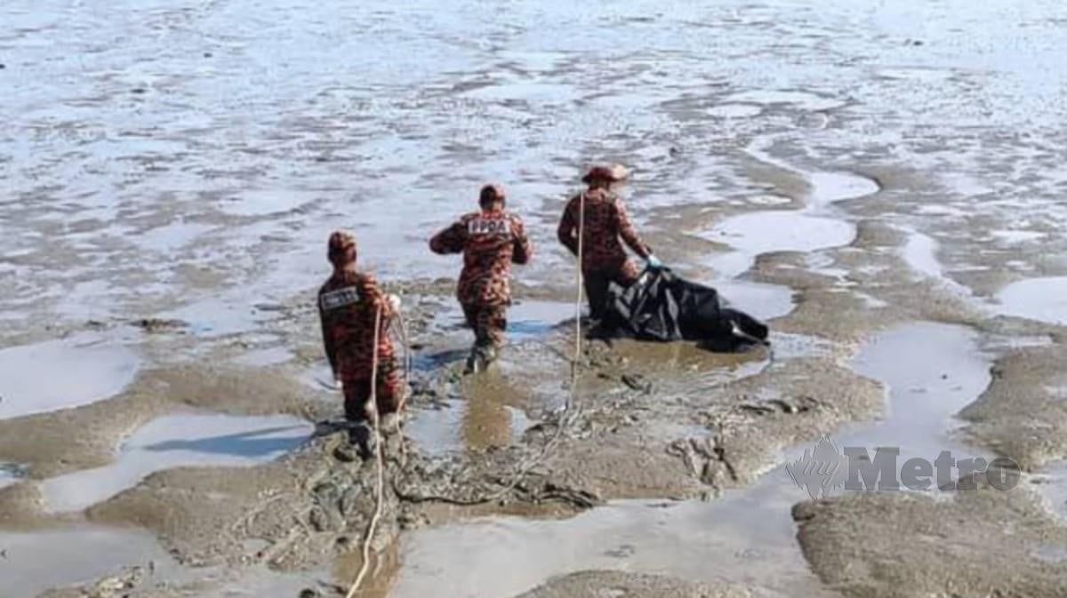 ANGGOTA Bomba meredah lumpur untuk mengambil mayat kanak-kanak perempuan terdampar di tepi pantai. FOTO Ihsan Bomba.