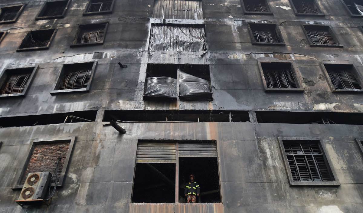 SEORANG anggota bomba berdiri di tingkap pertama kilang  Hashem Food and Beverage yang terbakar di Rupganj. FOTO AFP