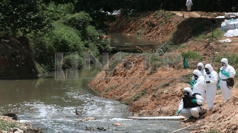 PEKERJA syarikat pembersihan memulakan kerja pembersihan sisa bahan toksik di Sungai Kim Kim. FOTO Mohd Azren Jamaludin