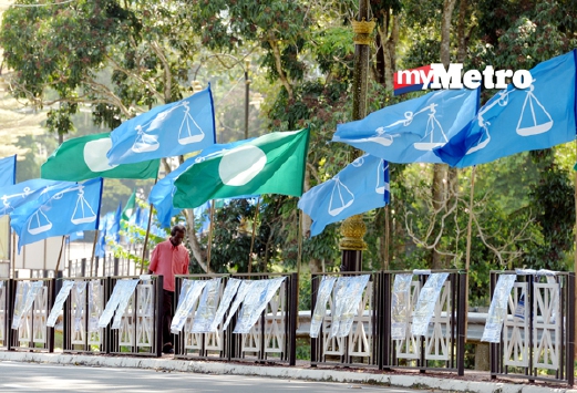 Bendera parti yang bertanding PRK Parlimen Kuala Kangsar berkibaran di sekitar Bukit Chandan. - Foto Bernama