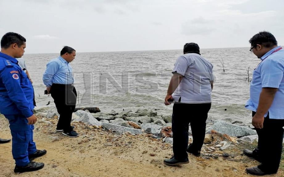 Mohd Zainal (dua kiri) meninjau ban bagi menghadapi fenomena air pasang besar di Klang. FOTO Norrasyidah Arshad 