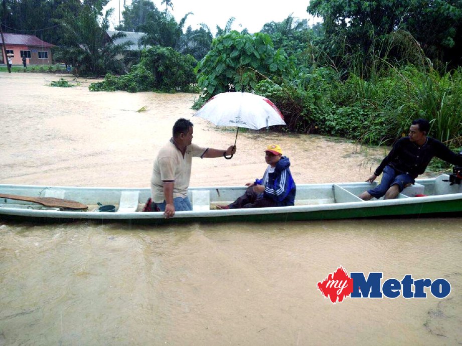 Mangsa banjir memindahkan ahli keluarga dan dokumen penting ke kawasan selamat berikutan banjir di Kampung Dusun, Lipis.  FOTO AMIR HAMZAH NORDIN 