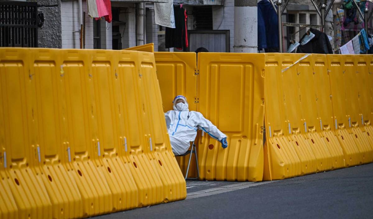 FOTO fail menunjukkan petugas memakai pakaian perlindungan diri mengawal pintu masuk  kawasan kejiranan di daerah Jing'an, Shanghai, pada Mac 2022. FOTO AFP
