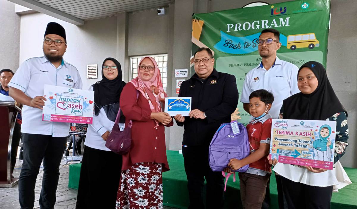 MEGAT Azlani  (tengah) menyampaikan sumbangan wang tunai dan kelengkapan persekolahan pada program 'Back To School' anjuran Pejabat Pembangunan Negeri (PPN) Melaka dan Yayasan Pembangunan Ekonomi Islam Malaysia (Yapeim) di Ayer Keroh. FOTO BERNAMA