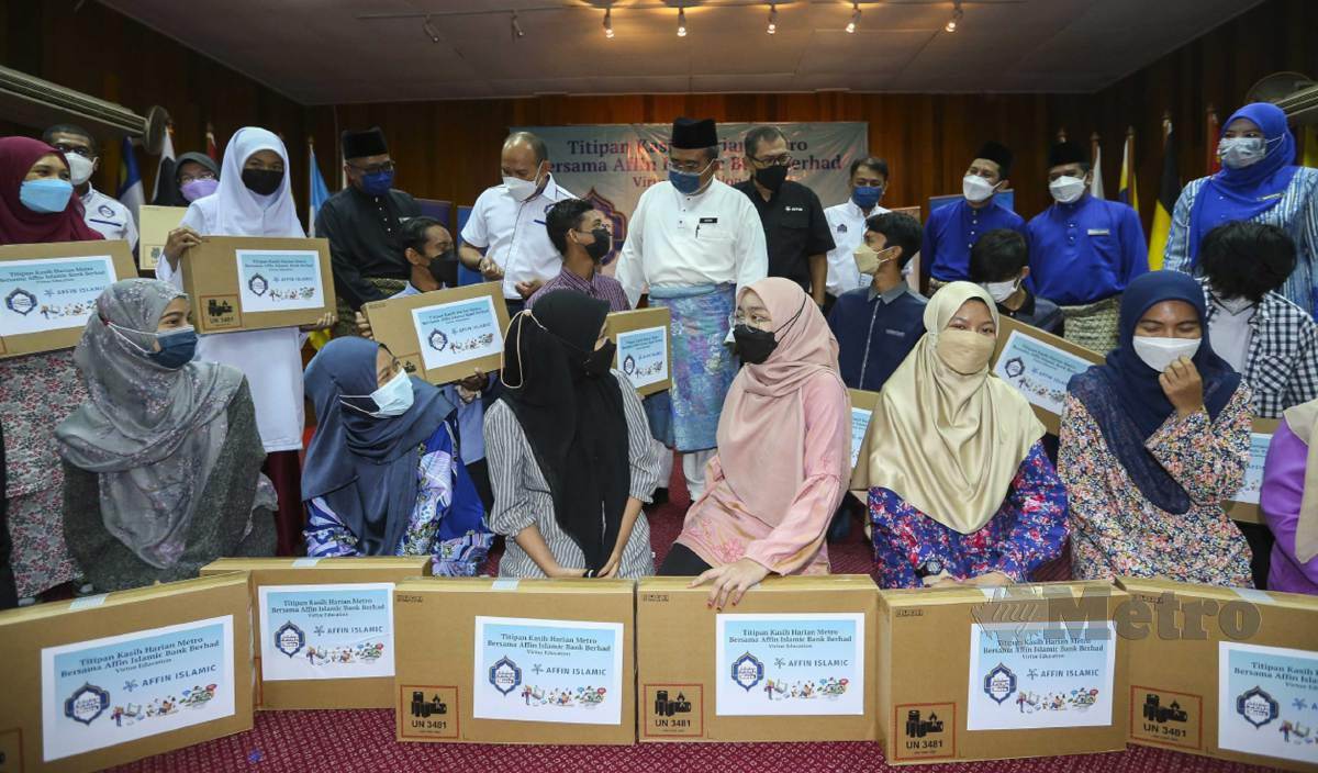 KARIM (tengah) berkatakan sesuatu kepada pelajar yang menerima komputer riba pada program Titipan Kasih Harian Metro Bersama Affin Islamic Bank di Jabatan Pendidikan Negeri Melaka. FOTO Azrul Edham Mohd Aminuddin