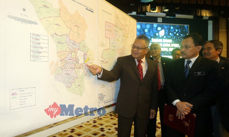 OTHMAN (kiri) kanan) dan Rosli (kanan) melihat peta kawasan PRK DUN Balakong selepas sidang media di Putrajaya, hari ini. FOTO Mohd Fadli Hamzah.