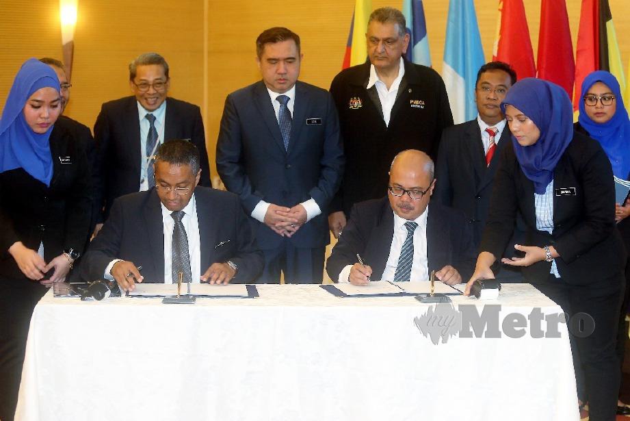 ANTHONY Loke (tengah) menyaksikan Azlan Shah (duduk kiri) dan wakil Syarikat Pengangkutan Maju Sdn Bhd Mat Salleh Hassan menandatangani dokumen ISBSF. FOTO Mohd Fadli Hamzah.