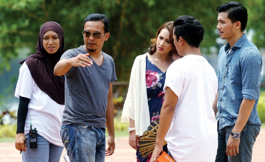 AZMI (dua dari kiri) memberi arahan kepada Fattah dan Fathia untuk satu babak dalam drama ini.