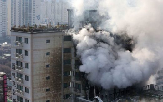 ANGGOTA bomba (atas bumbung) berusaha memadamkan kebakaran sebuah bangunan di utara Seoul, semalam.