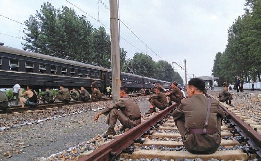 SEKUMPULAN anggota Tentera Rakyat Korea berehat menanti kereta api yang akan membawa mereka ke sempadan dengan Korea Selatan, minggu lalu.
