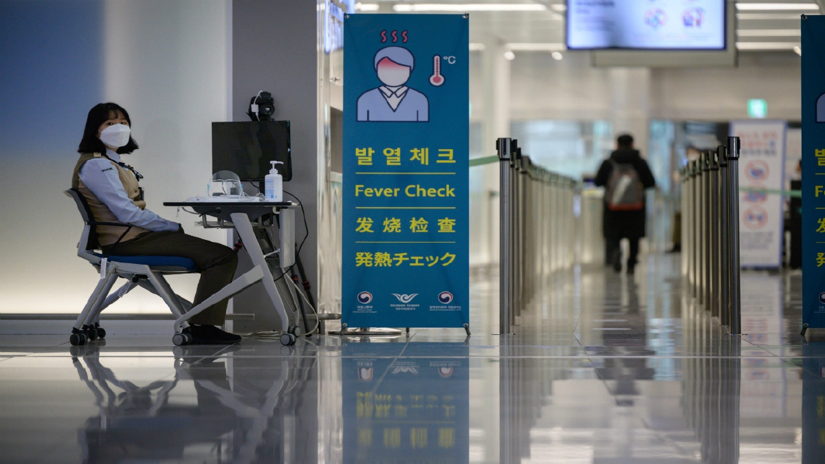 PETUGAS kesihatan menunggu penumpang untuk membuat pemeriksaan suhu di Lapangan Terbang Antarabangsa Incheon, Korea. FOTO AFP