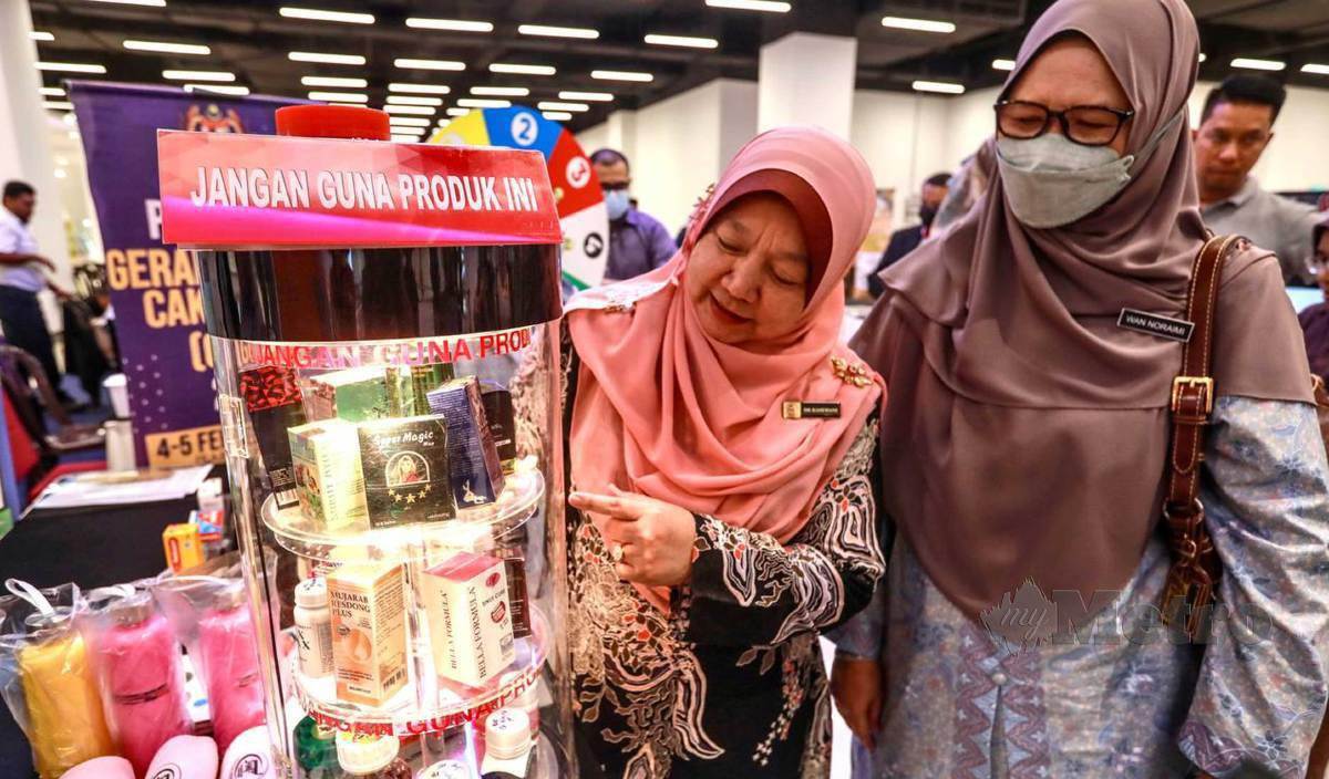 DR Kasemani (kiri) melihat produk dan kosmetik yang tidak berdaftar dengan Kementerian Kesihatan Malaysia (KKM) selepas merasmikan  Program Gerak Gempur Cakna Tahun 2023 di KTCC Mall. FOTO Ghazali Kori