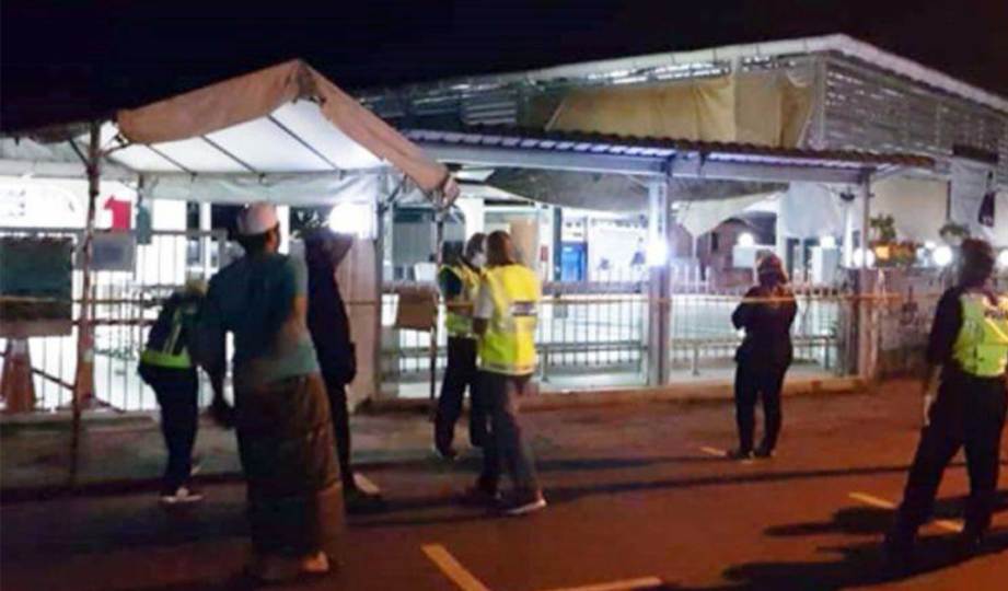 ANGGOTA polis memeriksa lokasi penemuan mayat bayi di dalam kotak di luar surau di Taman Sri Wangi, Kuching. FOTO Ihsan PDRM