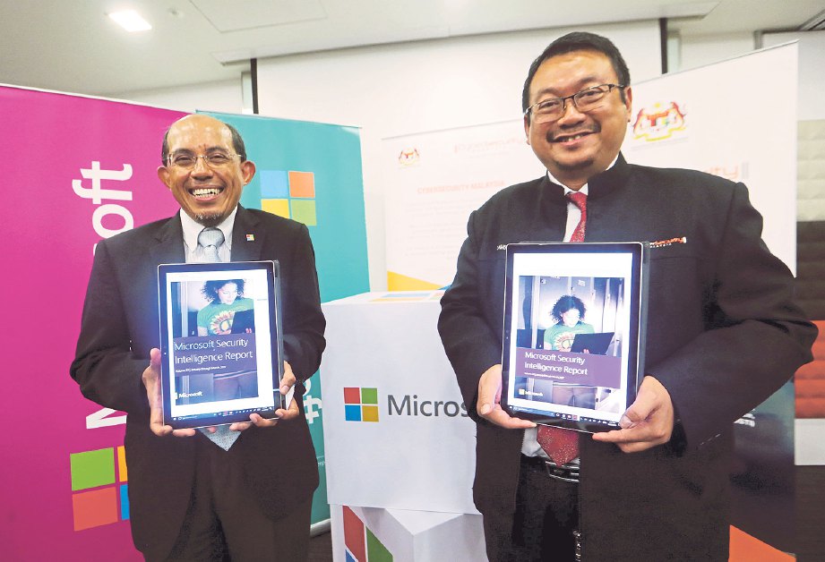 DR Dzahar (kiri) dan Dr Amirudin menunjukkan laporan keselamatan Microsoft.