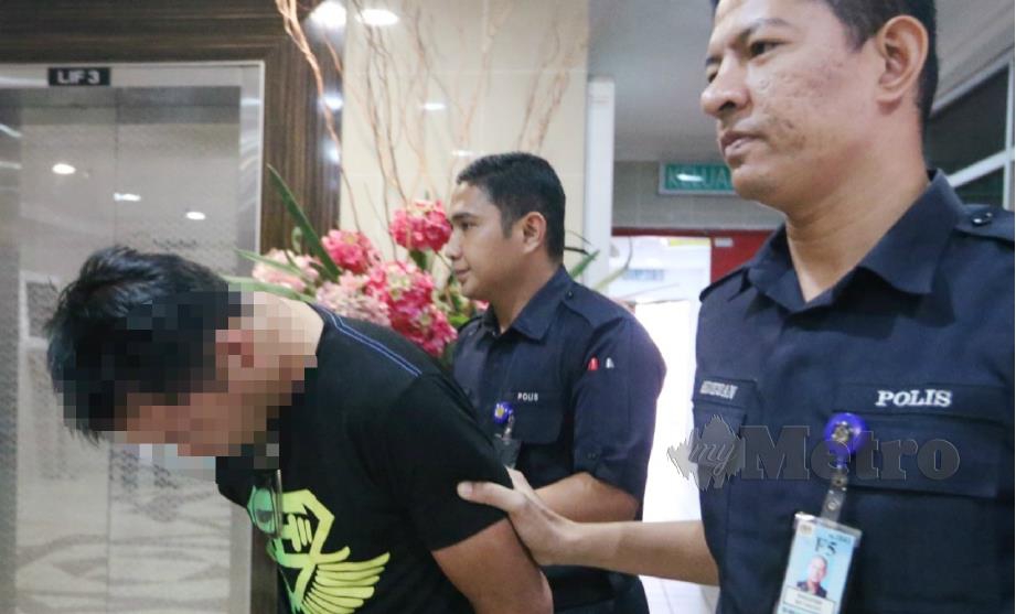 TERTUDUH diiring polis di Mahkamah Sesyen Kuala Terengganu, hari ini atas empat pertuduhan merogol, persetubuhan luar tabii dan amang seksual terhadap dua kanak-kanak. FOTO Imran Makhzan. 