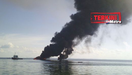 Kepulan asap tebal dari kapal membawa petrol yang terbakar berhampiran Kampung Cenderamata, Sandakan, petang tadi. - Foto HAZSYAH ABDUL RAHMAN