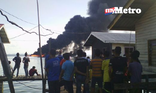 Orang ramai berkumpul melihat kapal yang terbakar. -  Foto HAZSYAH ABDUL RAHMAN