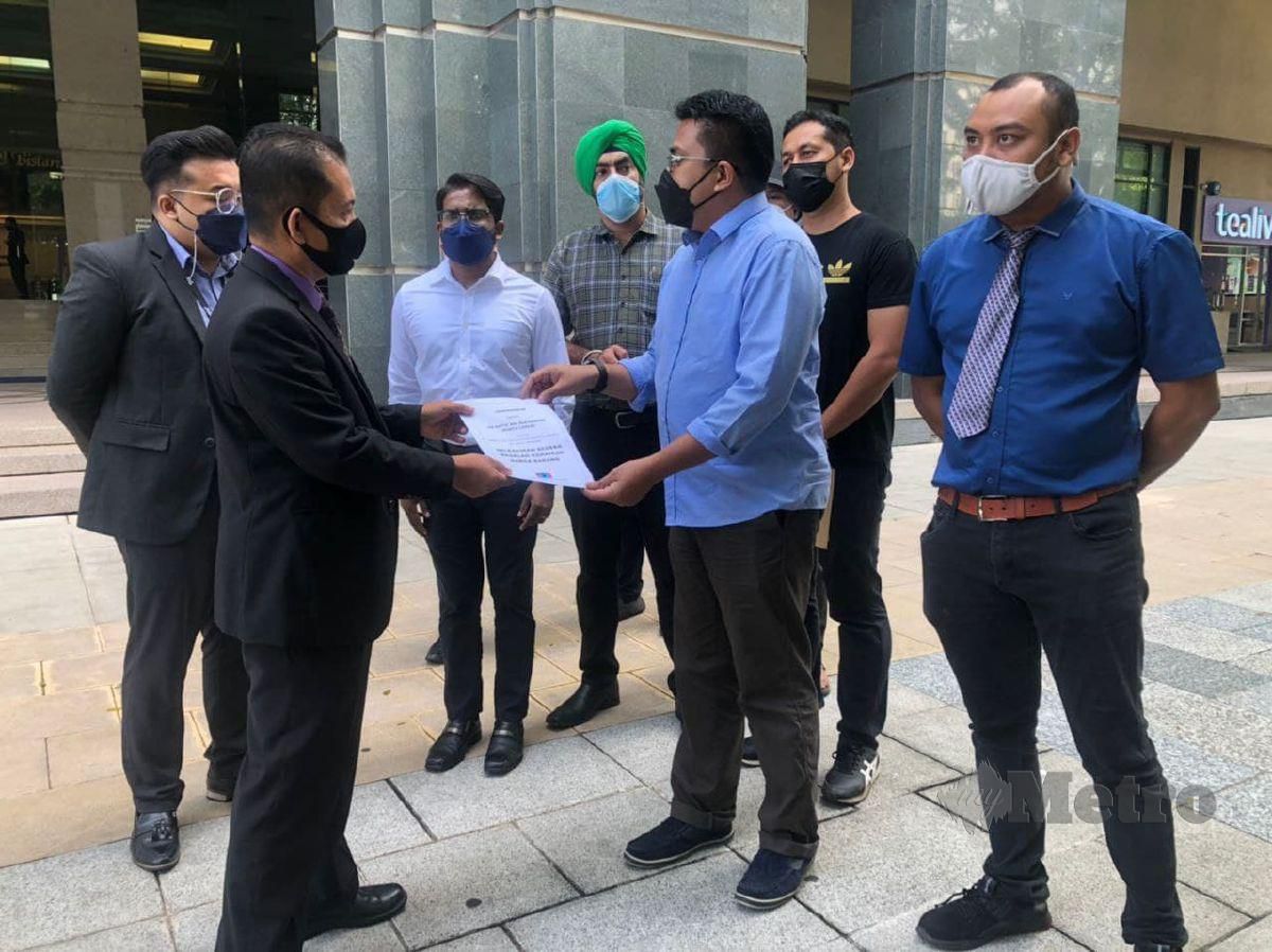 Ahmad Syukri (dua dari kanan) menyerahkan memorandum kepada  Mohd Arifin mewakil menteri KPDNHEP di lobi KPDNHEP, hari ini. FOTO SAMADI AHMAD