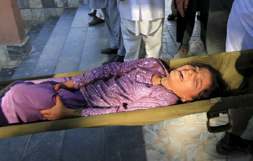 Anggota penyelamat membawa seorang budak perempuan yang merintih kesakitan ke sebuah hospital di Jalalabad, Afghanistan. - Foto REUTERS