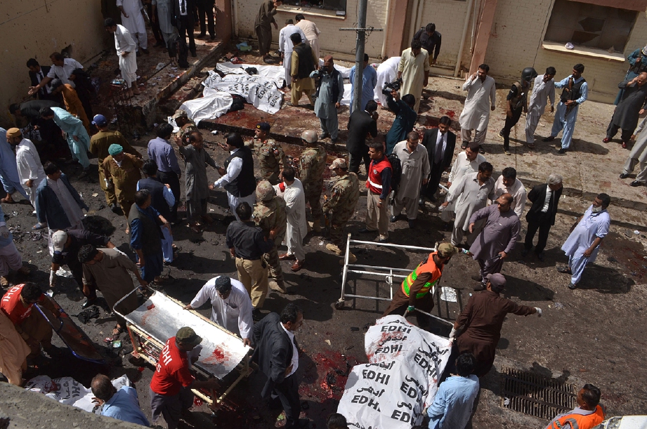 Polis dan pekerja hospital mengumpulkan mayat mangsa serangan bom di Hospital Awam Quetta. Seramai 67 orang disahkan terbunuh, sebahagian besarnya peguam. - Foto AFP