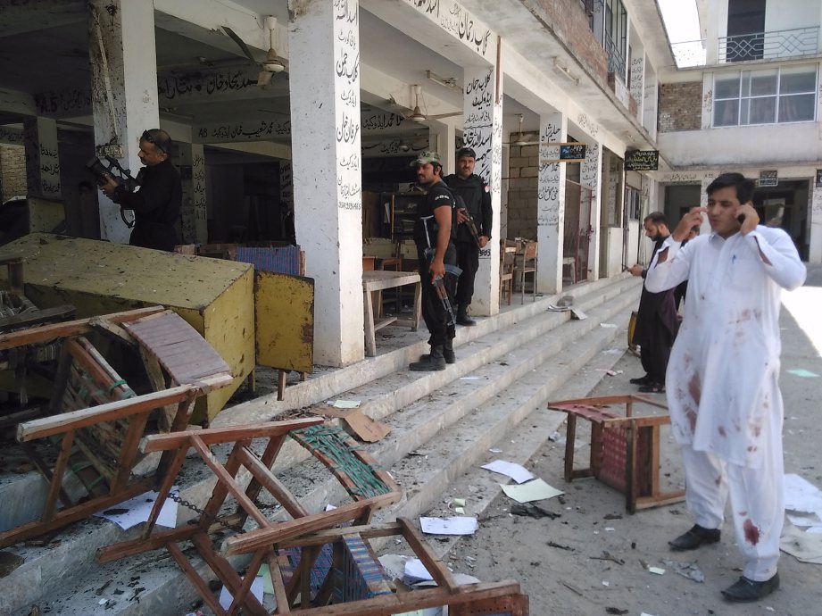 Anggota keselamatan Pakistan memeriksa lokasi serangan bom di sebuah mahkamah di Mardan, Pesahwar, hari ini. - Foto AFP