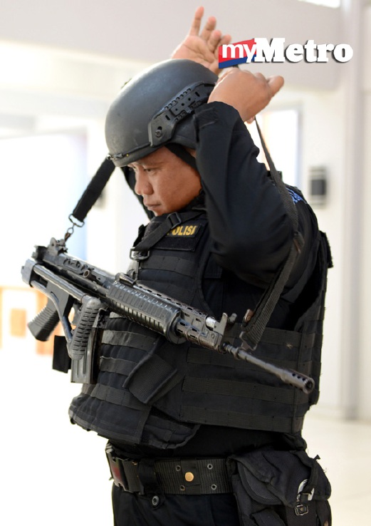 Seorang anggota pasukan khas polis membuat persediaan untuk berkawal di Lapangan Terbang Ngurah Rai, Denpasar. - Foto AFP