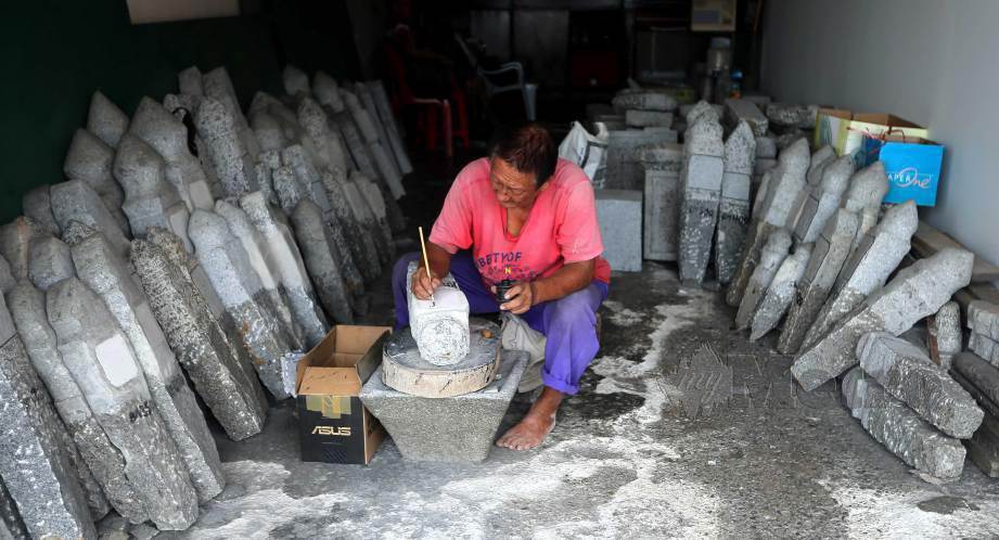 KUAH tekun menyiapkan tempahan batu nisan di bengkelnya di Pekan Lama Kuala Selangor. FOTO Saddam Yusoff