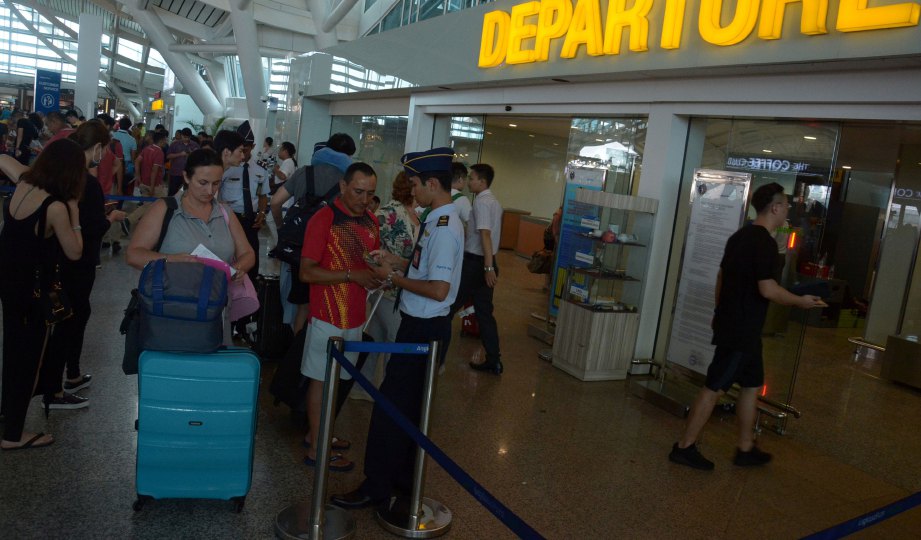 PENUMPANG beratur di pintu masuk pelepasan di Lapangan Terbang Antaranbangsa Ngurah Rai. FOTO  Antara Foto/Reuters