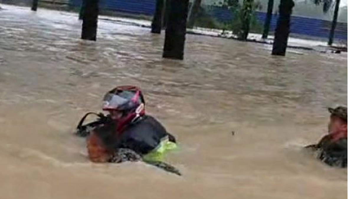 TANGKAP layar video tular anggota tentera membantu penunggang motosikal berkuasa tinggi bernombor pendaftaran Singapura yang dihanyutkan arus ketika cuba meredah banjir di Jalan Nitar, Mersing. 