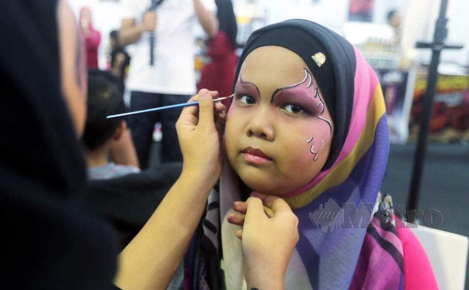 SEORANG kanak-kanak mengambil kesempatan melukis wajahnya di gerai pameran Expres.Je. FOTO Mohd Fadli Hamzah