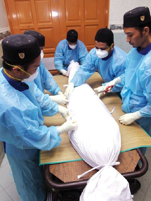 PROSES mengafankan jenazah selepas selesai dimandikan di bilik mayat Hospital Kuala Lumpur (HKL) oleh dikendalikan kakitangan JAWI.